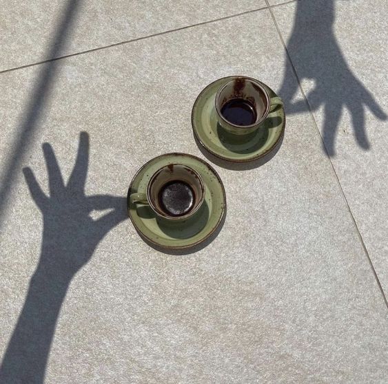 two shadow hands holding espresso cups
